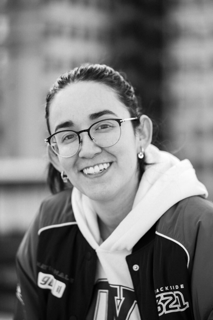 pexels-photo-15116426-15116426 Black and white portrait of a happy woman wearing glasses and a hoodie.